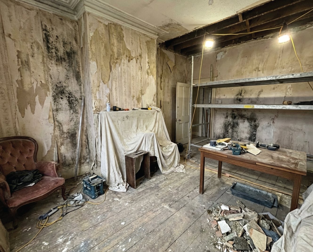 Salt-damaged plaster at the base of a wall before damp proofing works