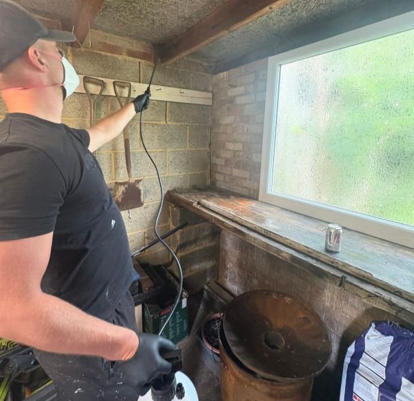 Proofterior technician injecting a chemical damp-proof course into a hacked-off masonry wall