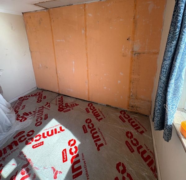 Insulated boarding being installed to a cold internal wall