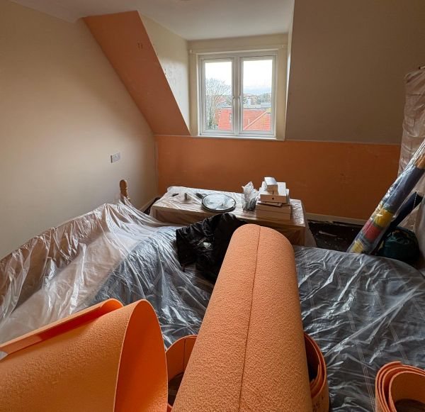 Loft insulation and ventilation works in progress in a roof void