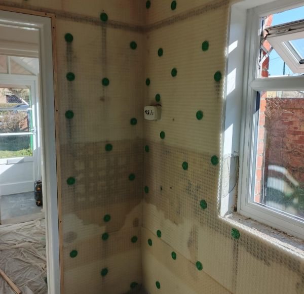 Cavity drain membrane being installed to a basement wall