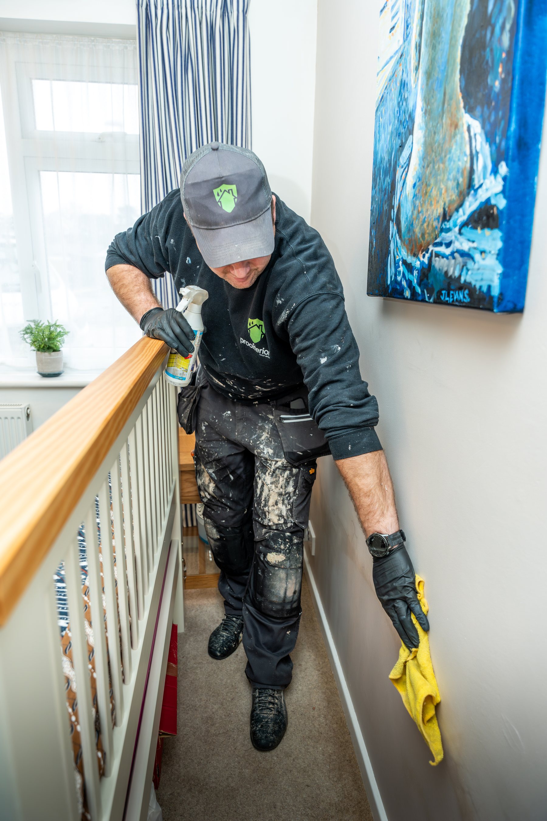 Surveyor inspecting masonry behind a removed skirting board